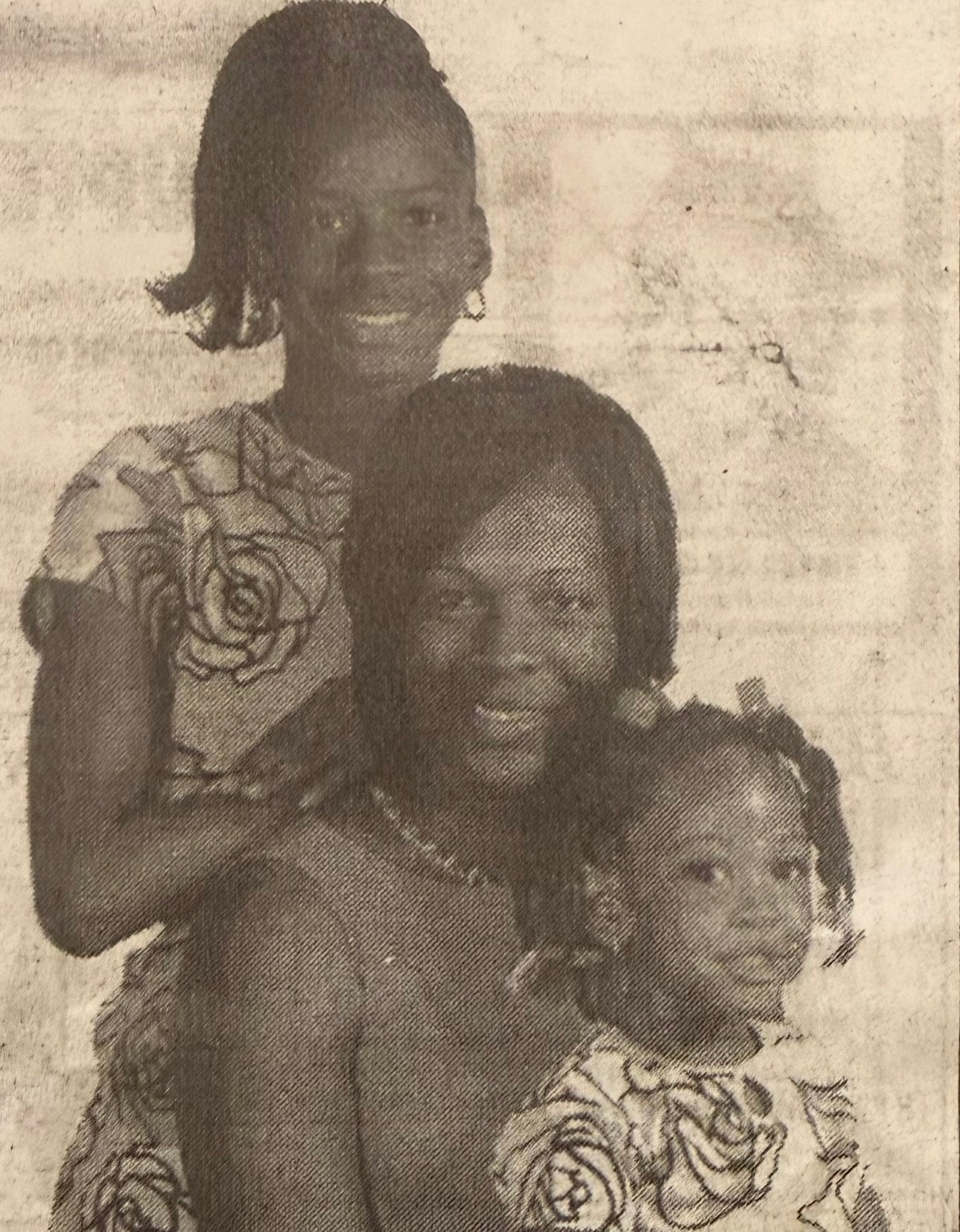 Faded newspaper photo of mother and daughters before restoration